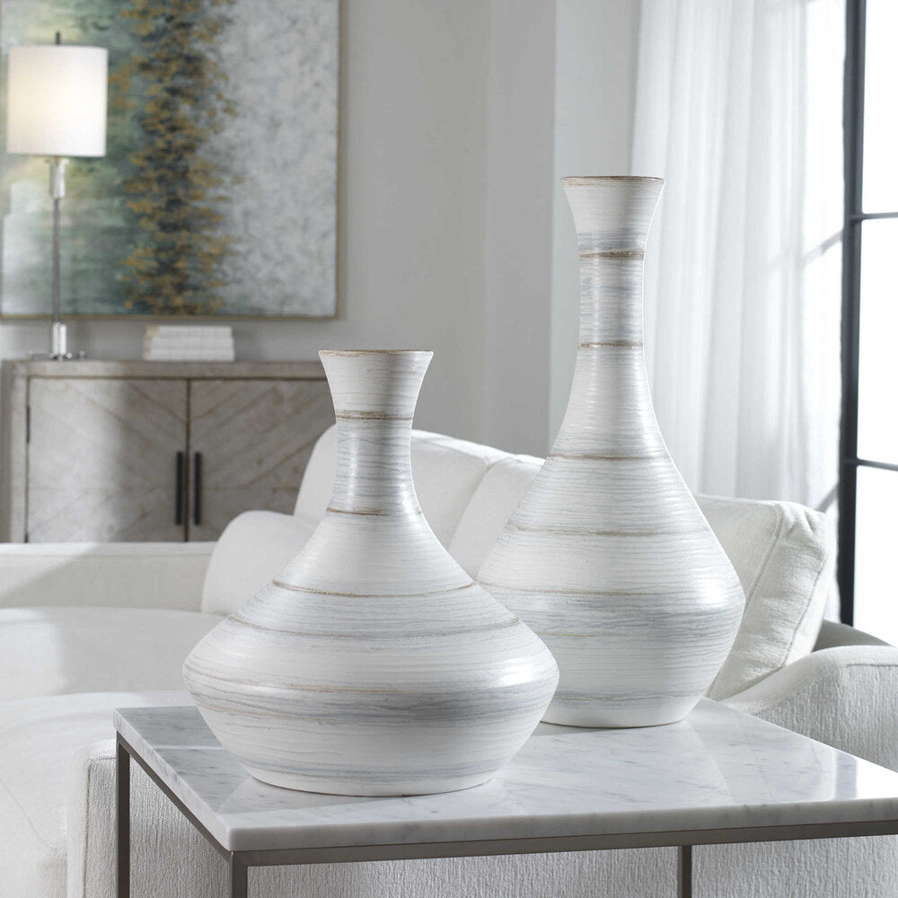 Close-up of handcrafted Potter vases featuring soft ivory, blue, and tan stripes, perfect for indoor or outdoor decor.