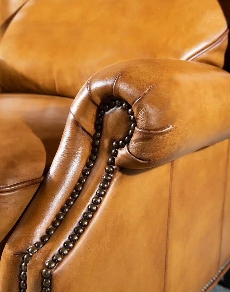 Close-up of the brass nailhead trim along the armrest of the Hollywood Leather Recliner, highlighting its classic elegance.