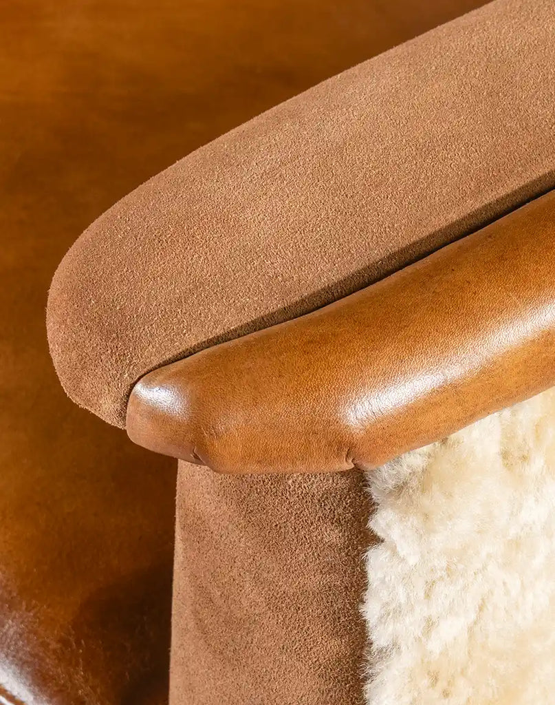 Close-up of the armrest featuring hand-burnished leather detailing and supple suede accents.