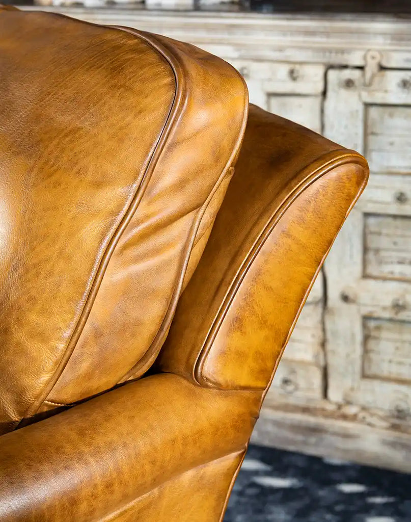 Close-up of the hand-burnished leather on the Hulton Swivel Glide Chair, showcasing its texture and quality.