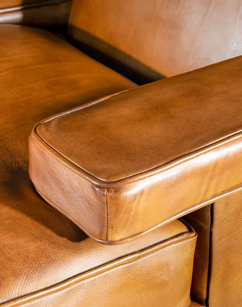 Close-up of the Jaxon Leather Chair armrest, showing detailed stitching and luxurious leather texture.