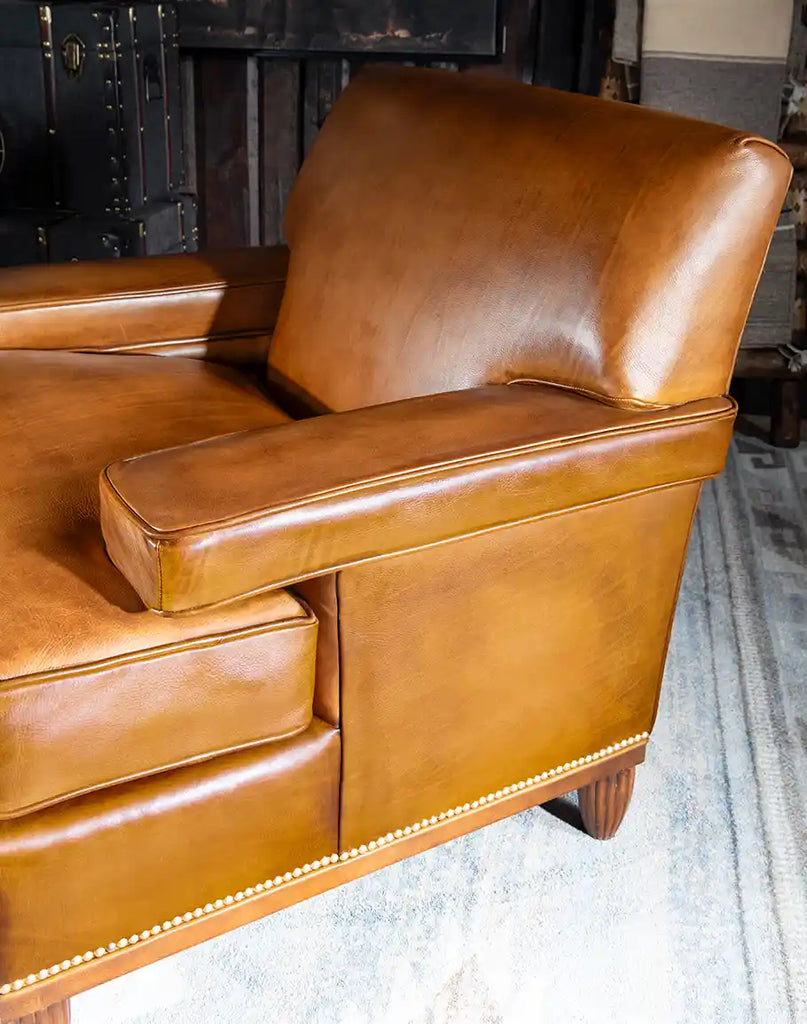 Side view of the Jaxon Leather Chair highlighting its uniquely designed armrests and rustic details.