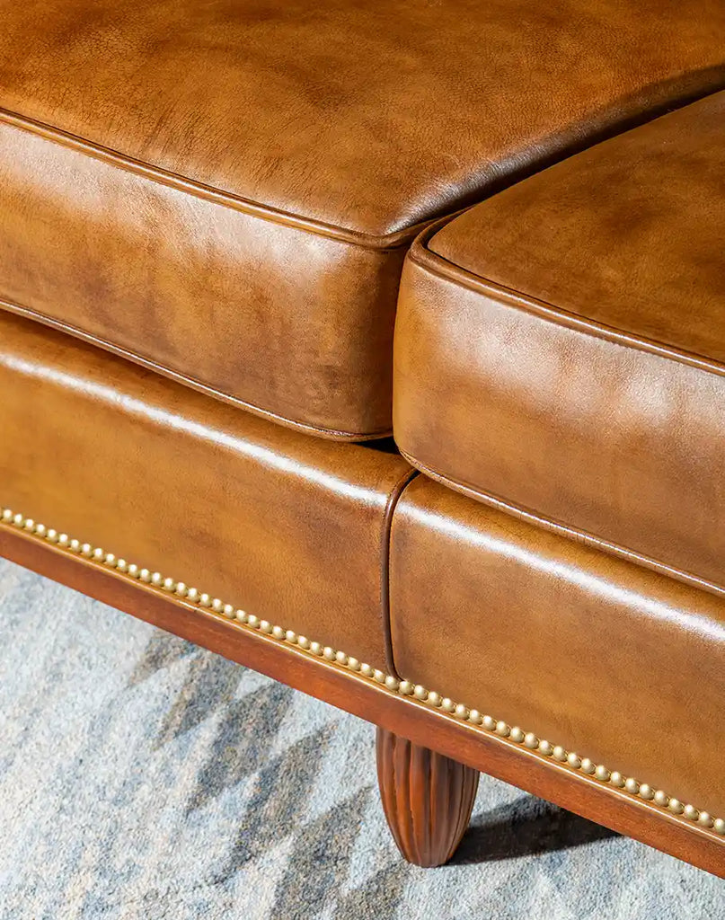 Close-up of the gold-colored nail tacks on the Jaxon Leather Sofa adding a touch of sophistication.