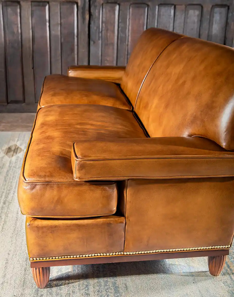 Side profile of the Jaxon Leather Sofa highlighting the sleek armrest and hand-burnished details.