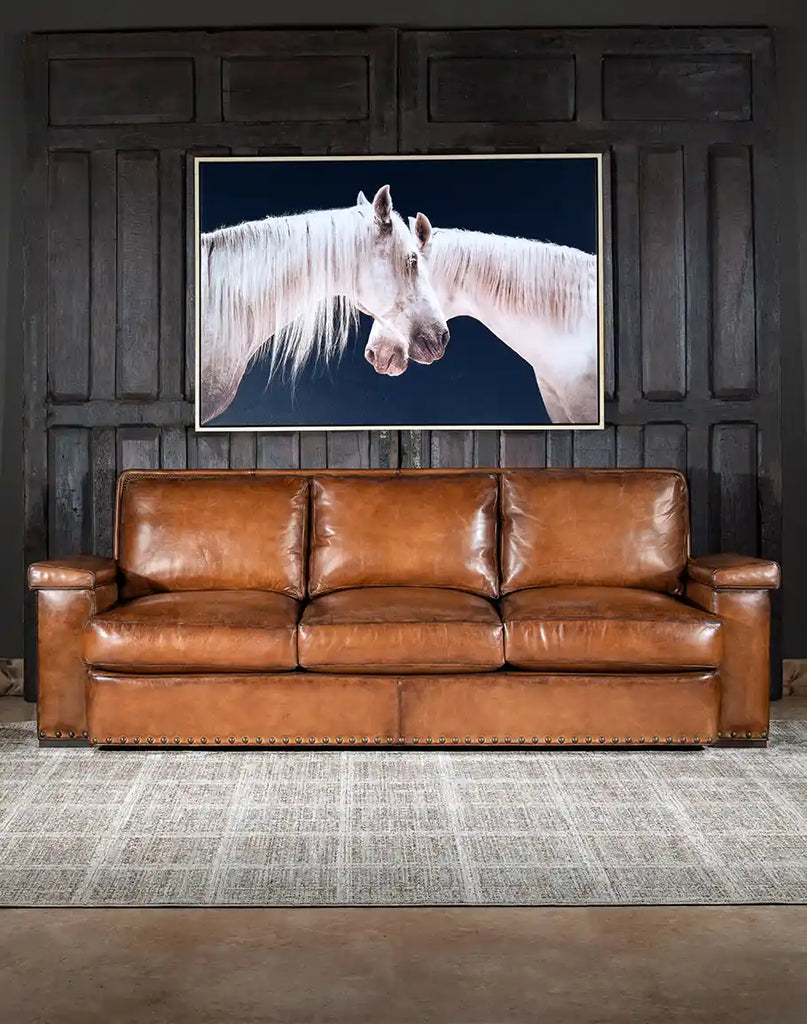 Front-facing image showcasing the full length of the Jefferson Leather Sofa, highlighting its hand-burnished full grain leather and brass nail accents.