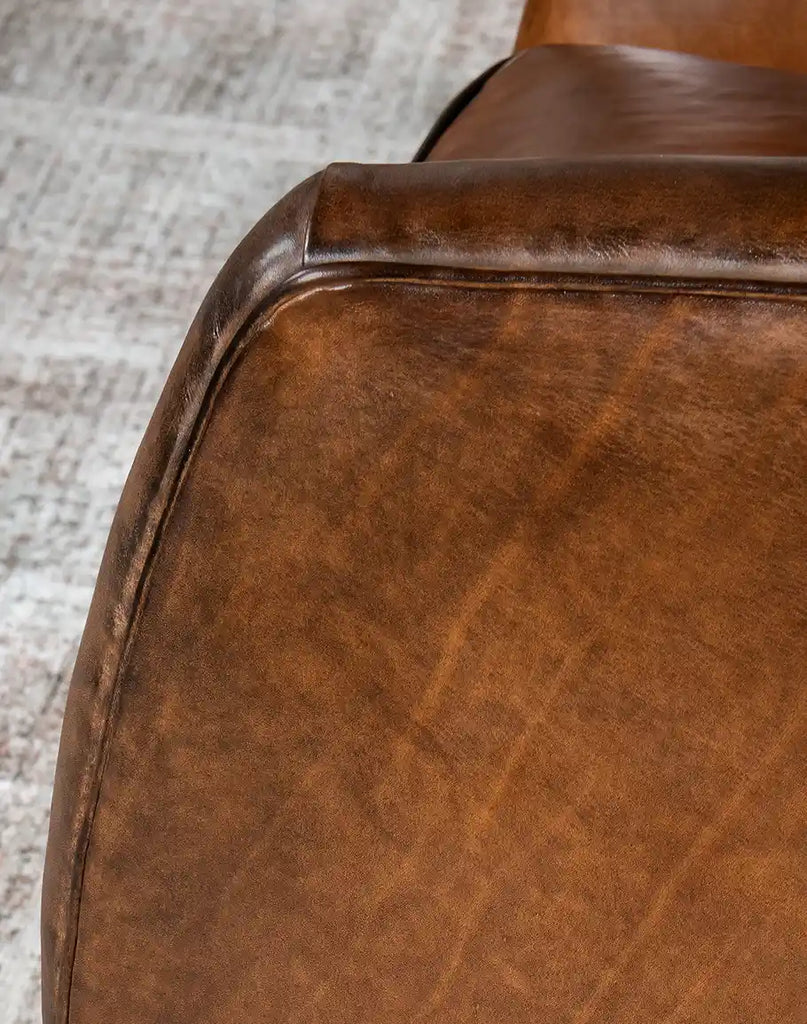 Close-up of the hand-burnished full-grain leather on the Johnson Leather Chair, showcasing its unique natural variations.