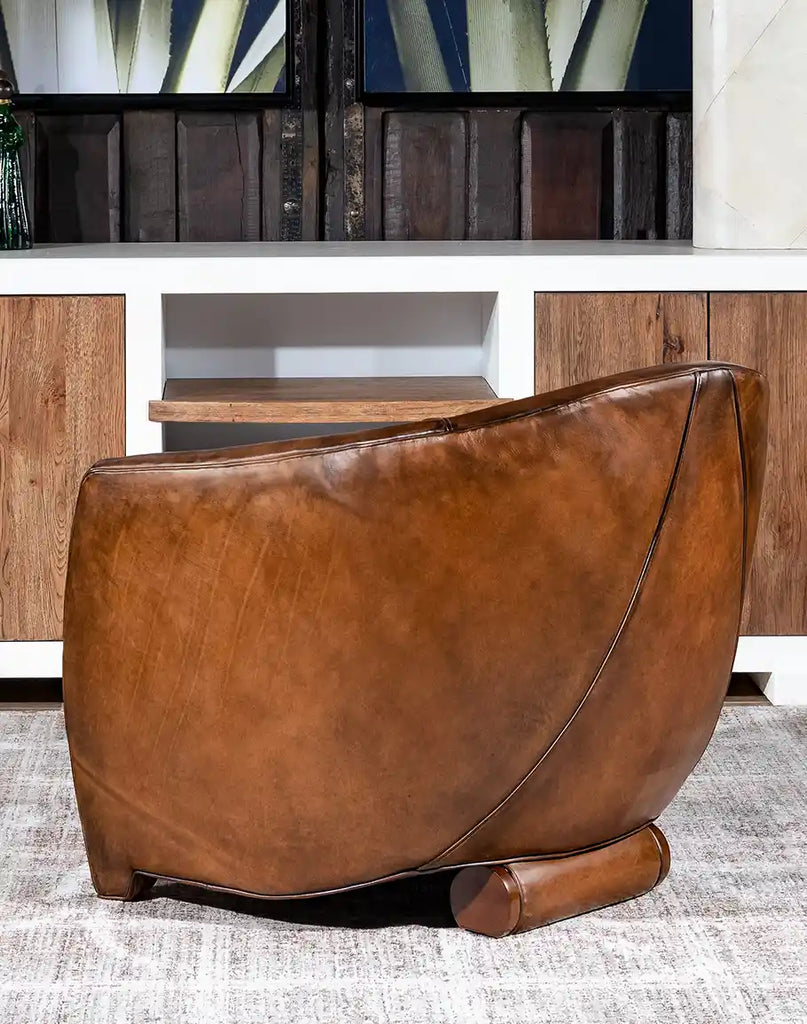 Side profile of the Johnson Leather Chair emphasizing its elegant curved back and compact size.