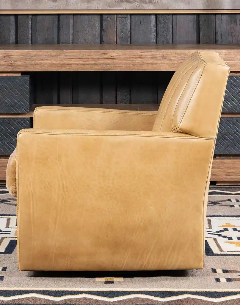 Side view of the Kobi Sand Swivel Chair emphasizing its swivel base and the hand-burnished detailing on the leather.