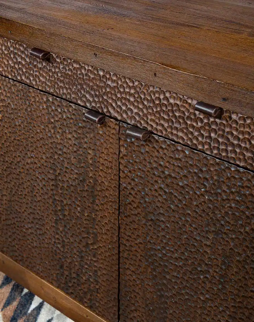 Detailed view of the two-tone stained effect on the hand-chiseled panels of the La Flor Dominicana Buffet, resembling hammered copper.