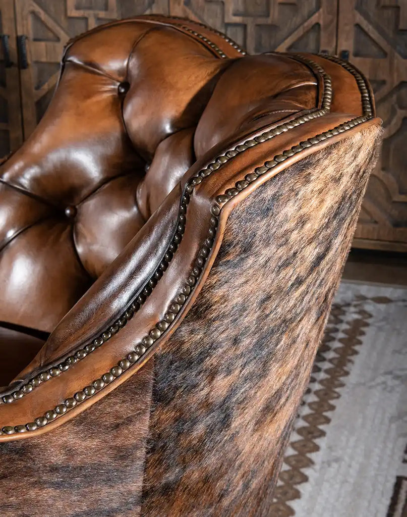 Close-up of the brindle cowhide upholstery on the Medina Brindle Swivel Glider, adding rustic charm to its design.