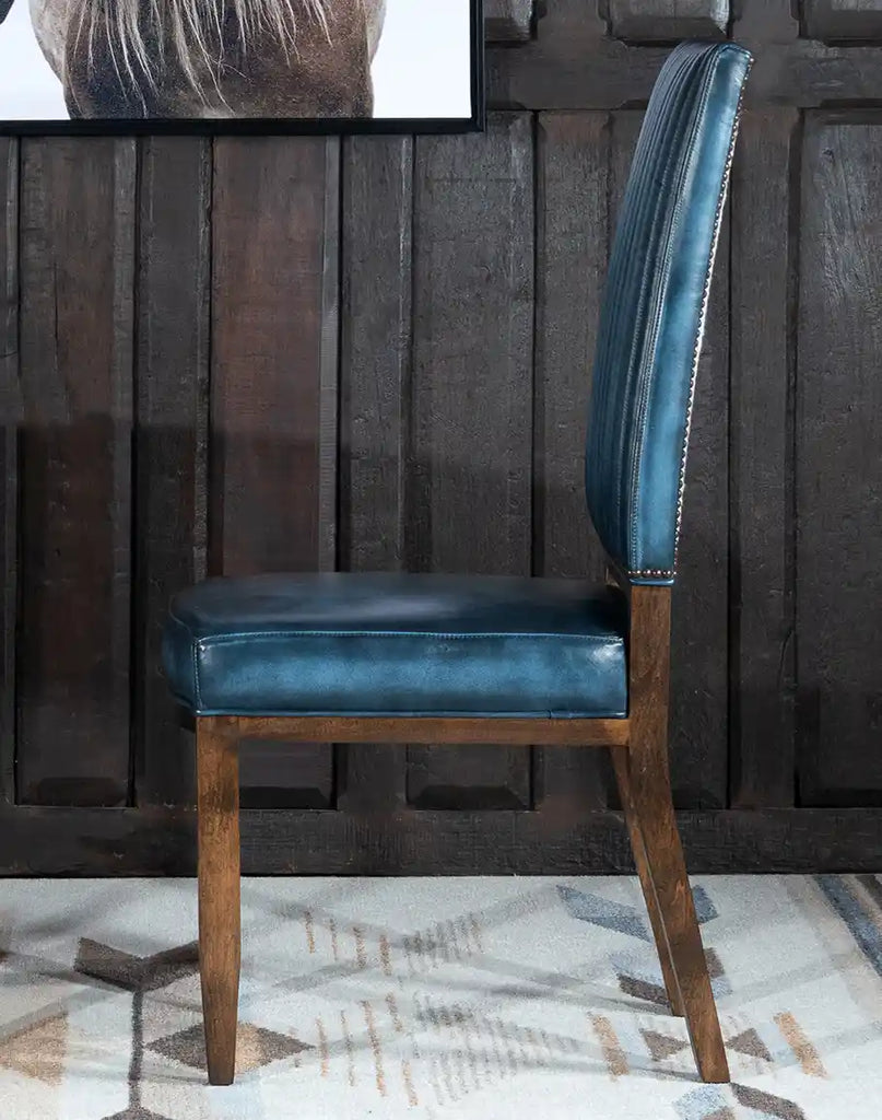 Side profile highlighting the chair's sleek lines and the contrast between the blue leather seat and the wooden frame.