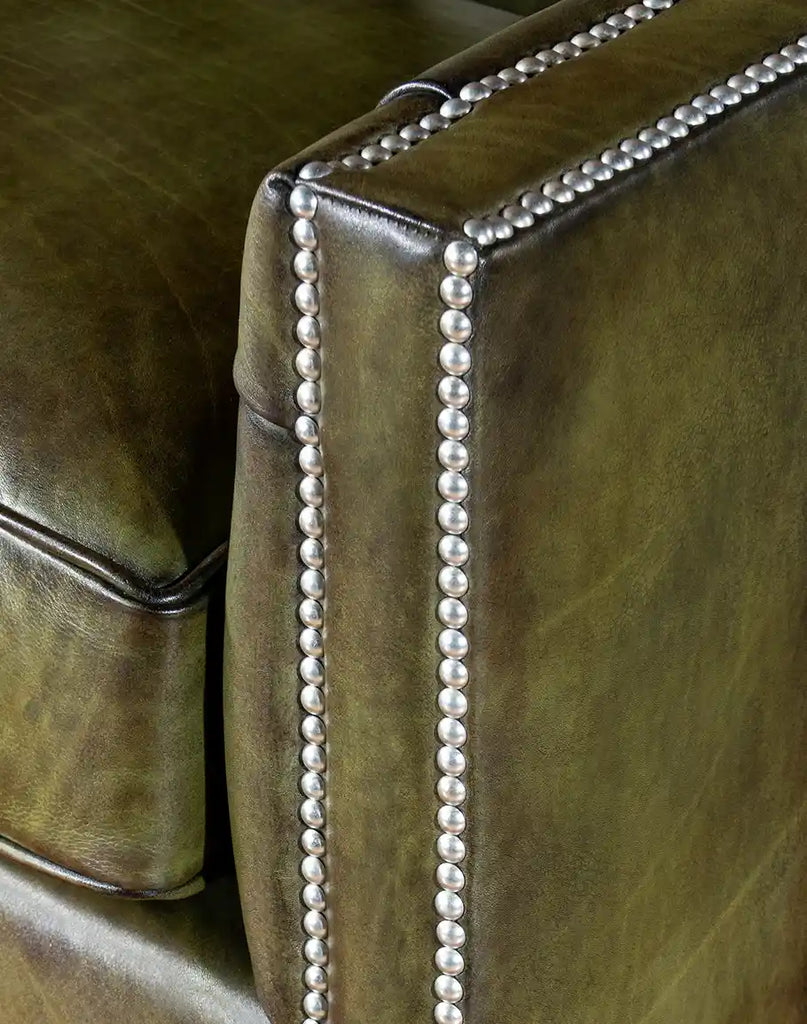 Close-up image focusing on the nickel nail head trim along the arm rails, highlighting the chair's refined detailing.