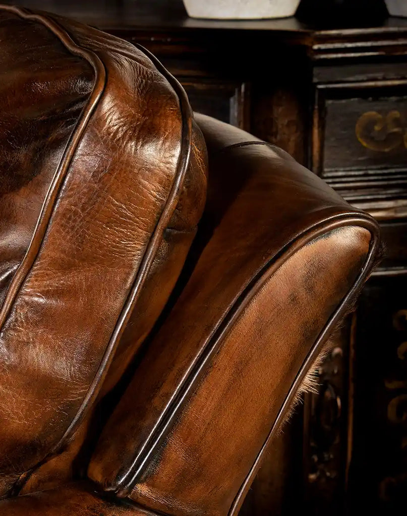 Close-up of the luxurious hand-burnished mocha leather on the Mocha Leather Swivel Glider, showcasing its premium quality.