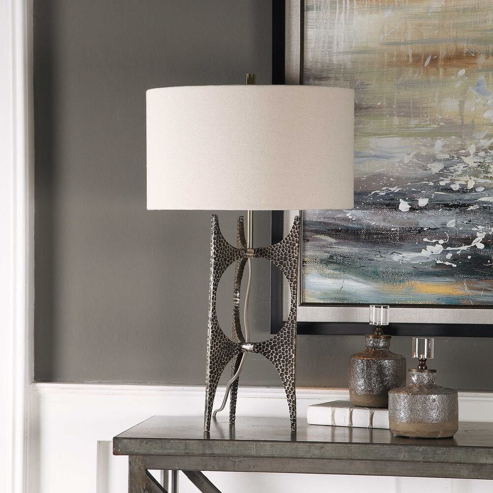 Elegant modern lamp with an antique golden bronze cast iron base, white linen shade, and exposed fabric-wrapped cord.