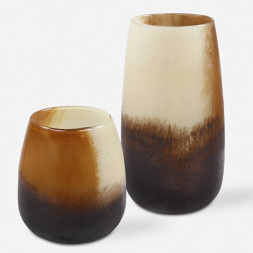 Beautiful glass vases with a mix of earthy colors from sand to deep bronze, ideal for complementing floral displays or candle decor.