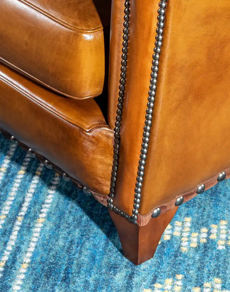 A detailed view of the sturdy wooden base of the Norse Leather Sofa, complementing its elegant leather design.