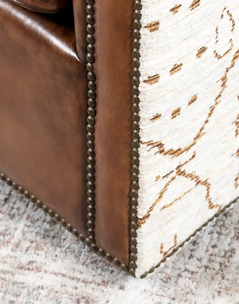 Close-up of the seamless blend of patterned fabric and leather on the Oceanside Swivel Chair for an elegant finish.