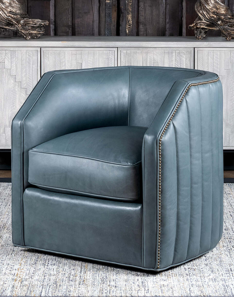 Olga Grey Swivel Chair, showcasing its elegant slate blue full-grain leather upholstery and barrel design.