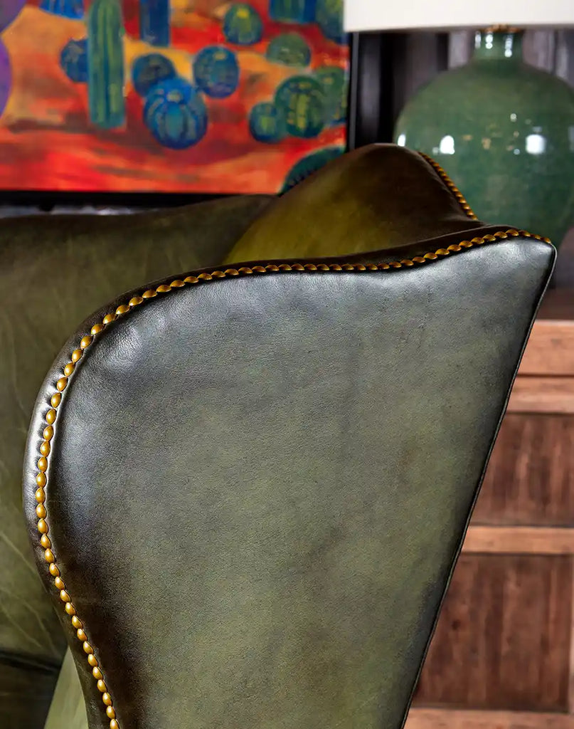 Close-up of the hand-brushed olive-green leather upholstery, showcasing its texture and quality.