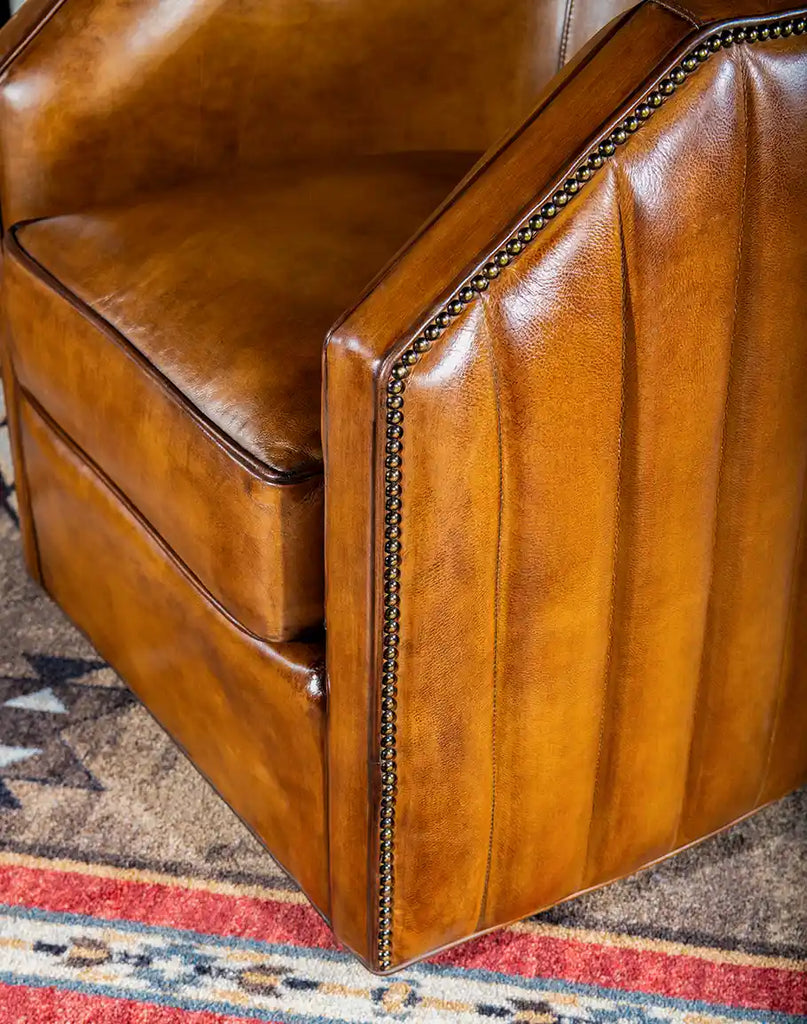 A detailed close-up of the hand-burnished accents on the Olivia Leather Swivel Chair, showcasing its rich texture and expert craftsmanship.