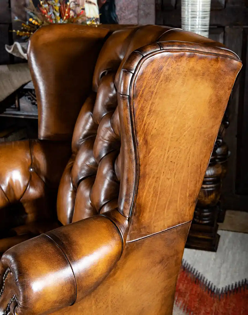 Angled side view of the Olivia Tufted Leather Chair highlighting its elegant wingback silhouette and timeless craftsmanship.