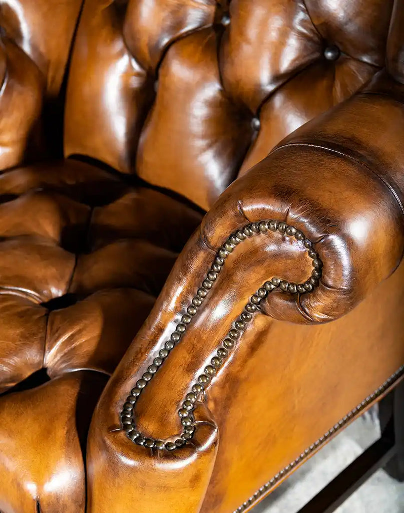 Close-up of the curved armrest on the Olivia Tufted Leather Chair, crafted with hand-burnished leather for added comfort and style.