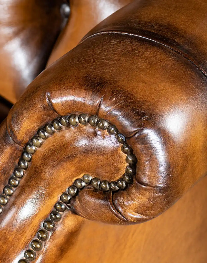 Close-up of the gold nail tack detailing on the Olivia Tufted Leather Chair, adding a touch of sophistication and elegance.