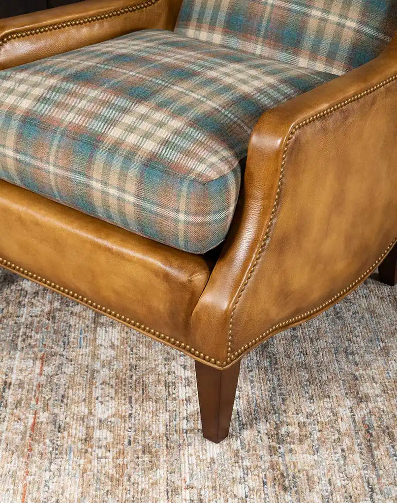 Close-up of the armrest on the Patterned Spruce Chair, featuring luxurious leather and brass nail tack detailing.