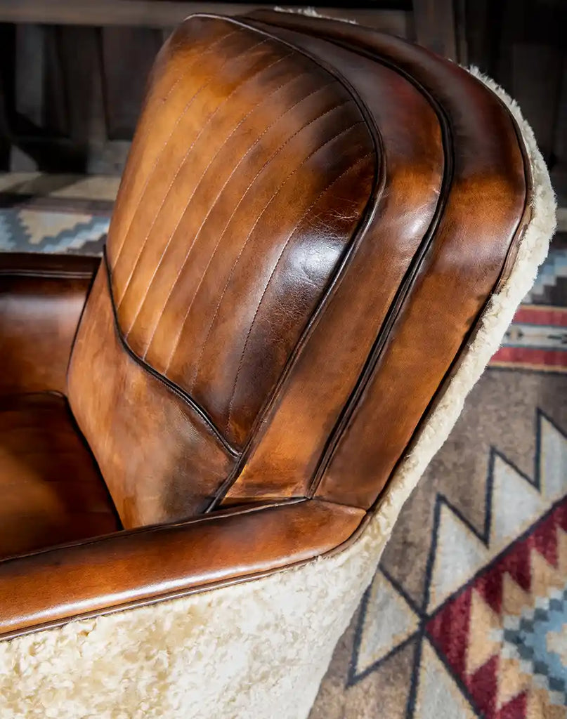 Side perspective displaying the chair’s elegant curves, shearling-covered outer arms, and parallel stitching details.