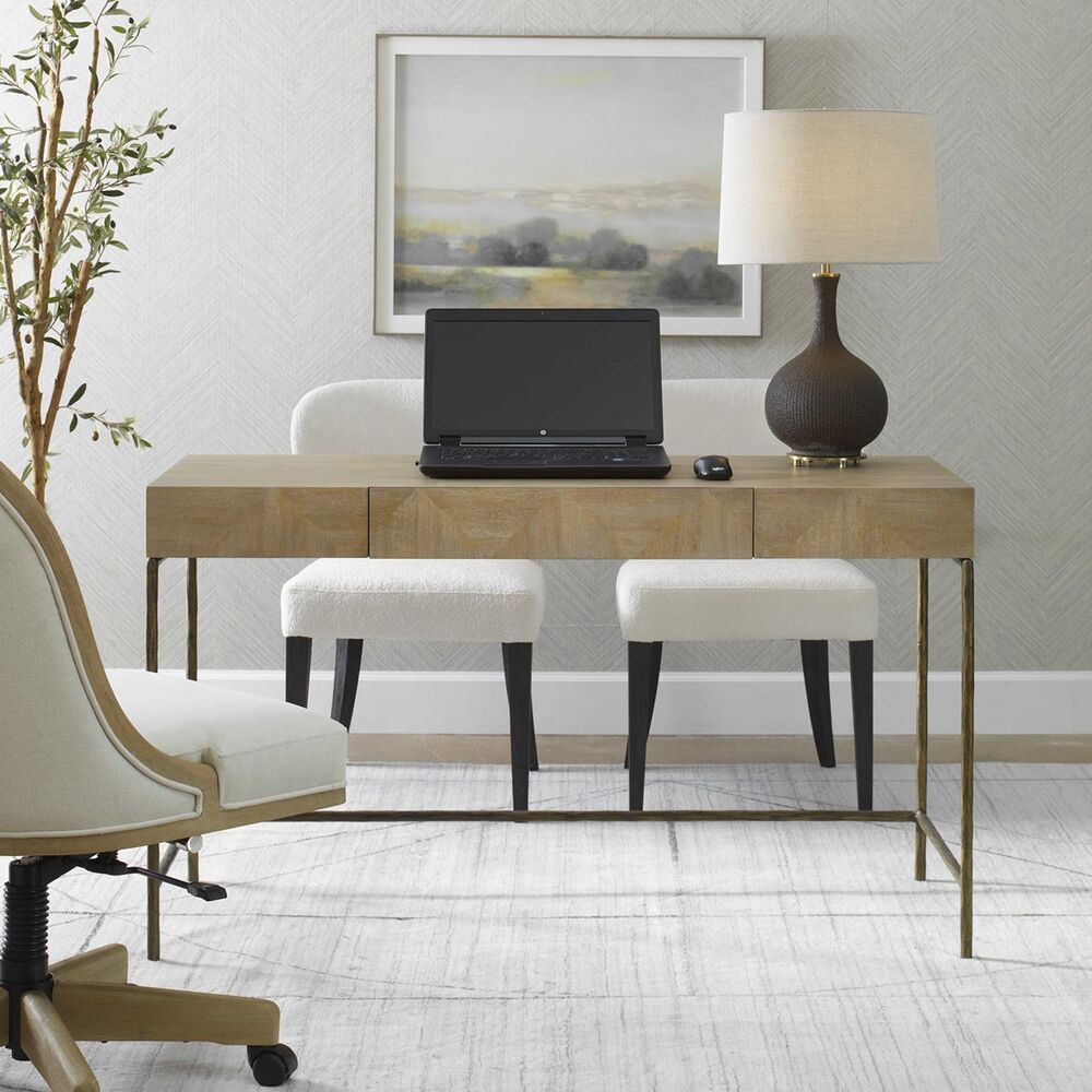 Modern desk with vibrant primavera wood veneer and antique gold cast iron base, featuring a central storage drawer.