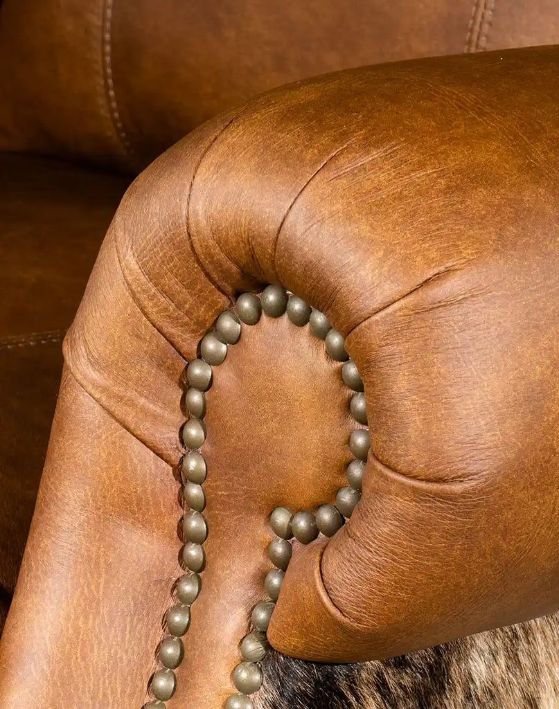 Close-up of the armrest with nail head trim and leather finish on the Rancher Brindle Recliner.