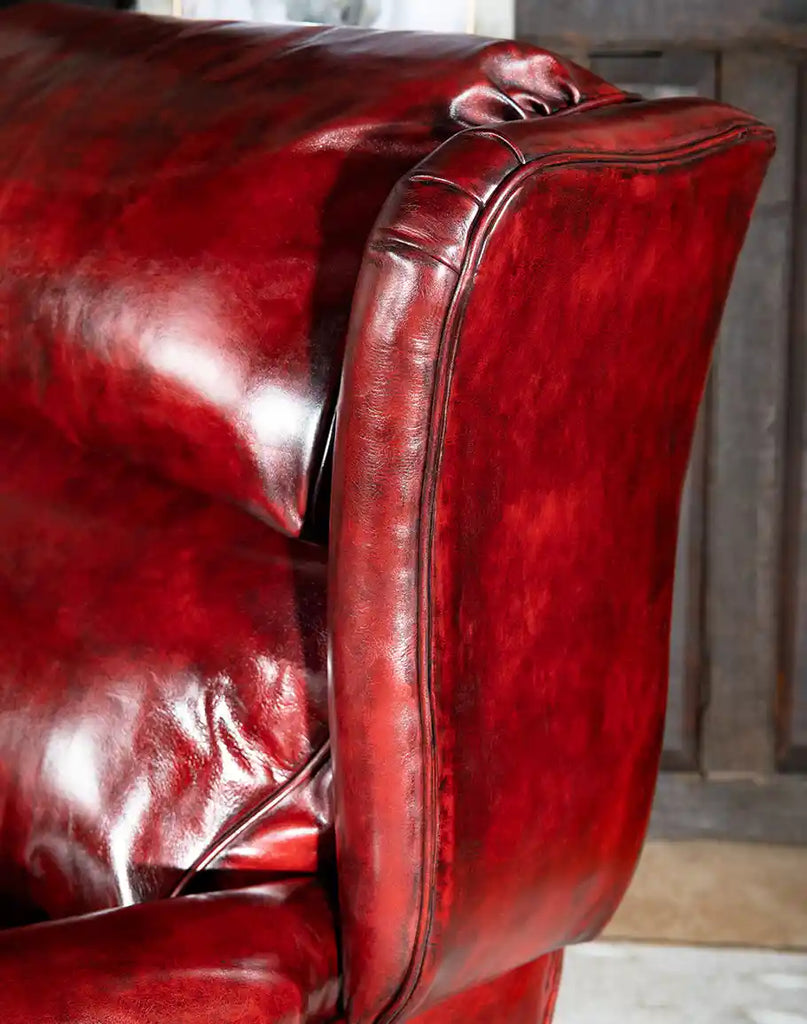 Close-up of the hand-antiqued dark red leather on the Raspberry Leather Recliner, highlighting its rich color and texture.