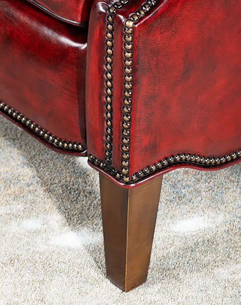 Close-up of the Raspberry Leather Recliner's wooden legs, showcasing their robust construction and finish.