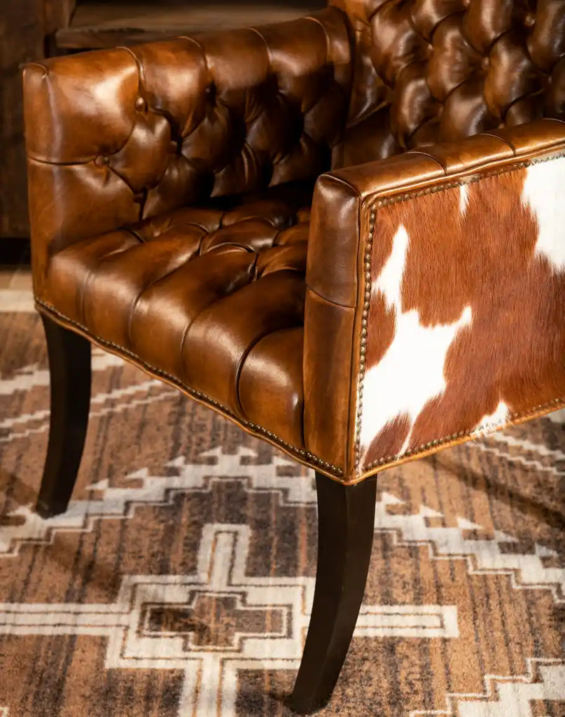 Detailed view of the Revo Tufted Leather Chair's handcrafted wooden legs, designed for durability and classic style.