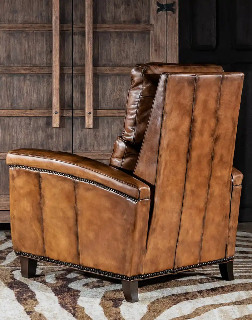 Side angle of the Revolt Bourbon Leather Recliner, highlighting its tapered arms and hand-finished details.