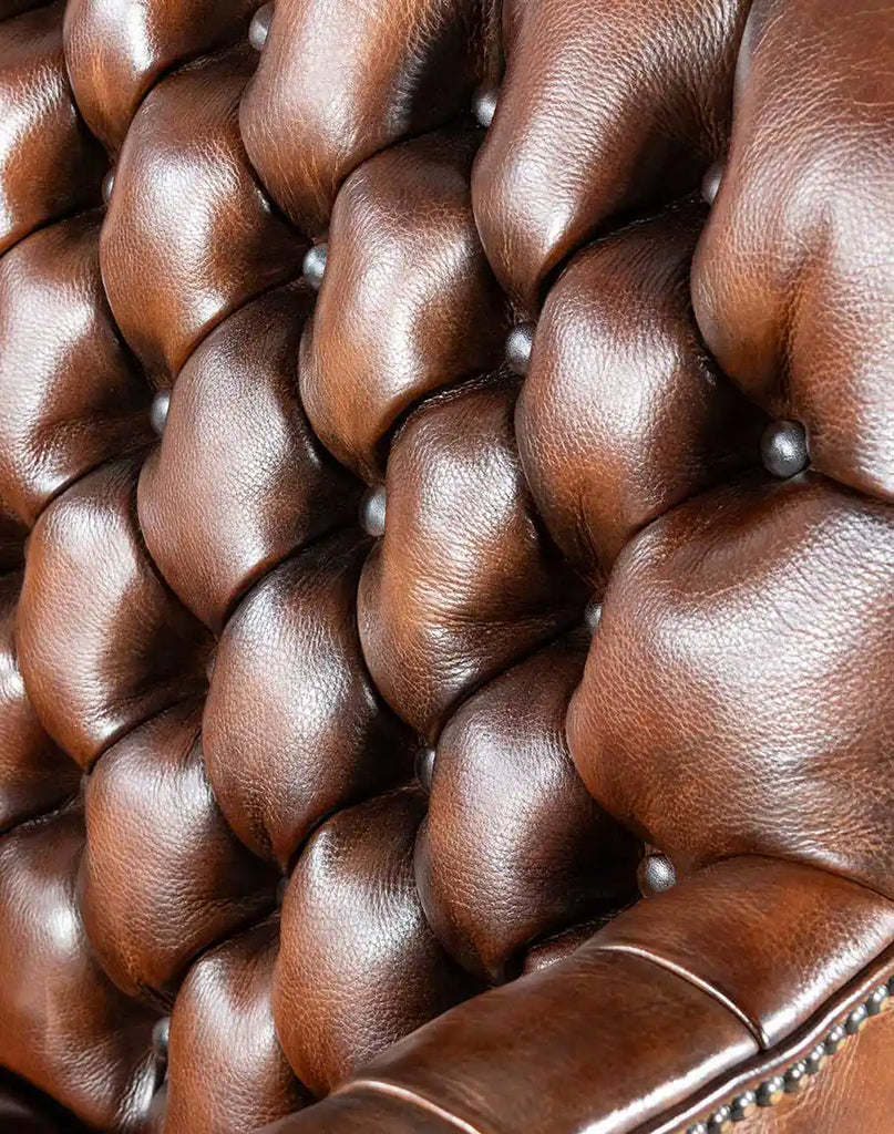 Close-up of the deep button tufting on the seat, back, and inside arms of the Roan Sable Tufted Leather Chair.