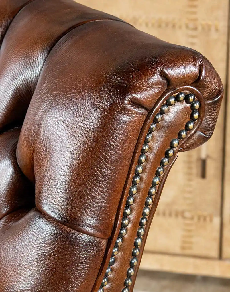 Close-up image capturing the rich texture and hand-burnished finish of the Roan Sable Tufted Leather Chair's full-grain leather.