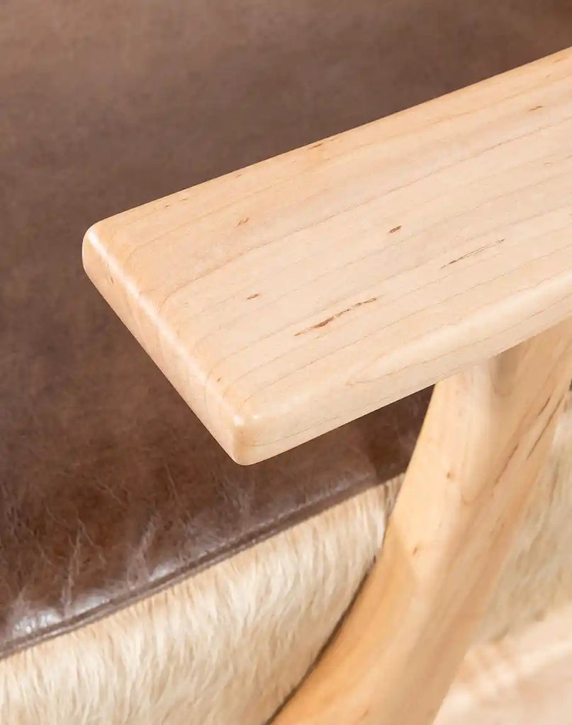 Detailed shot of the Robin Leather Chair's leather armrest and stitching.