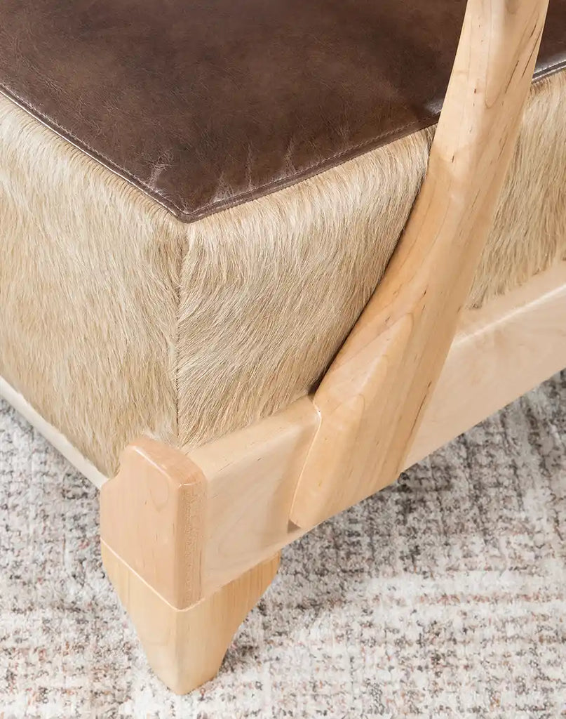 Close-up of the Robin Leather Chair's sturdy wooden legs and base design.