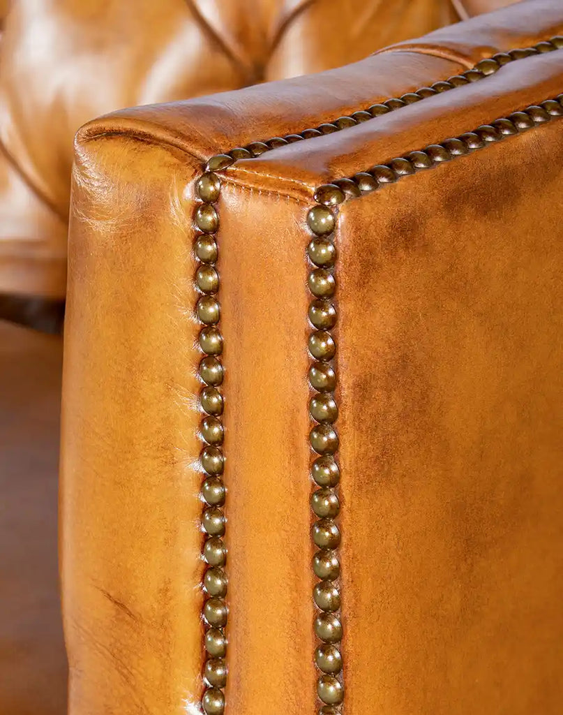 Close-up of the straight armrest with brass nailhead accents on the Rochfort Chesterfield Sofa.