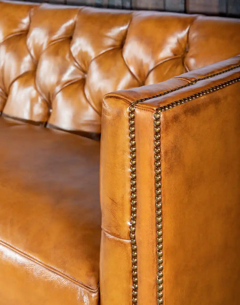 Elegant brass nailhead trim outlining the Rochfort Chesterfield Sofa’s structured arm design.