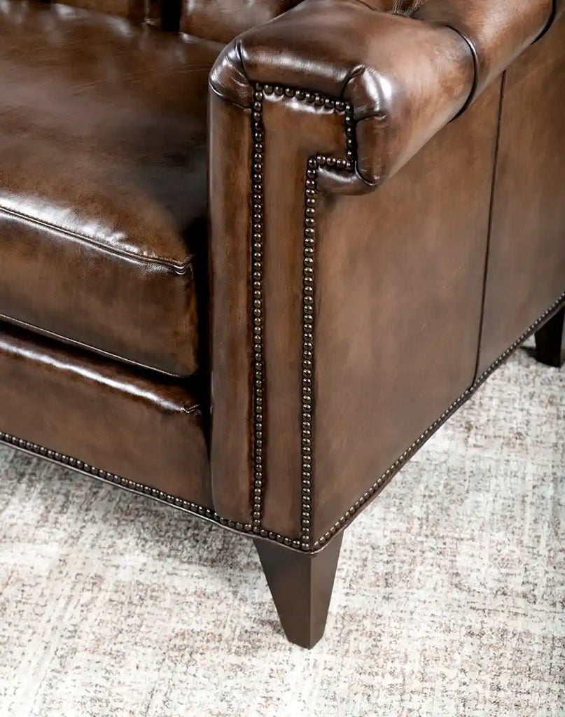 Detailed view of the brass nail tacks adorning the edges of the Rockwood Smoked Chesterfield Sofa for a refined finish.