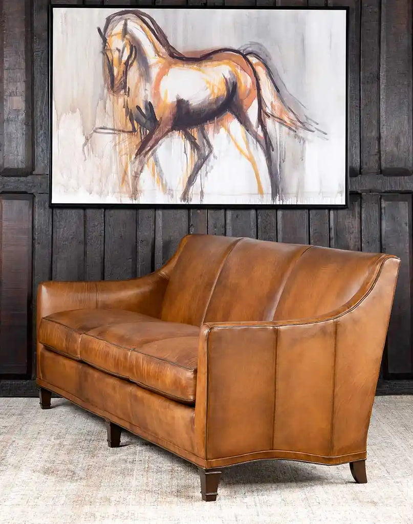 Angled perspective of the Rudy Saddle Leather Sofa highlighting its hand-burnished details and contrasting light chocolate leather welt.