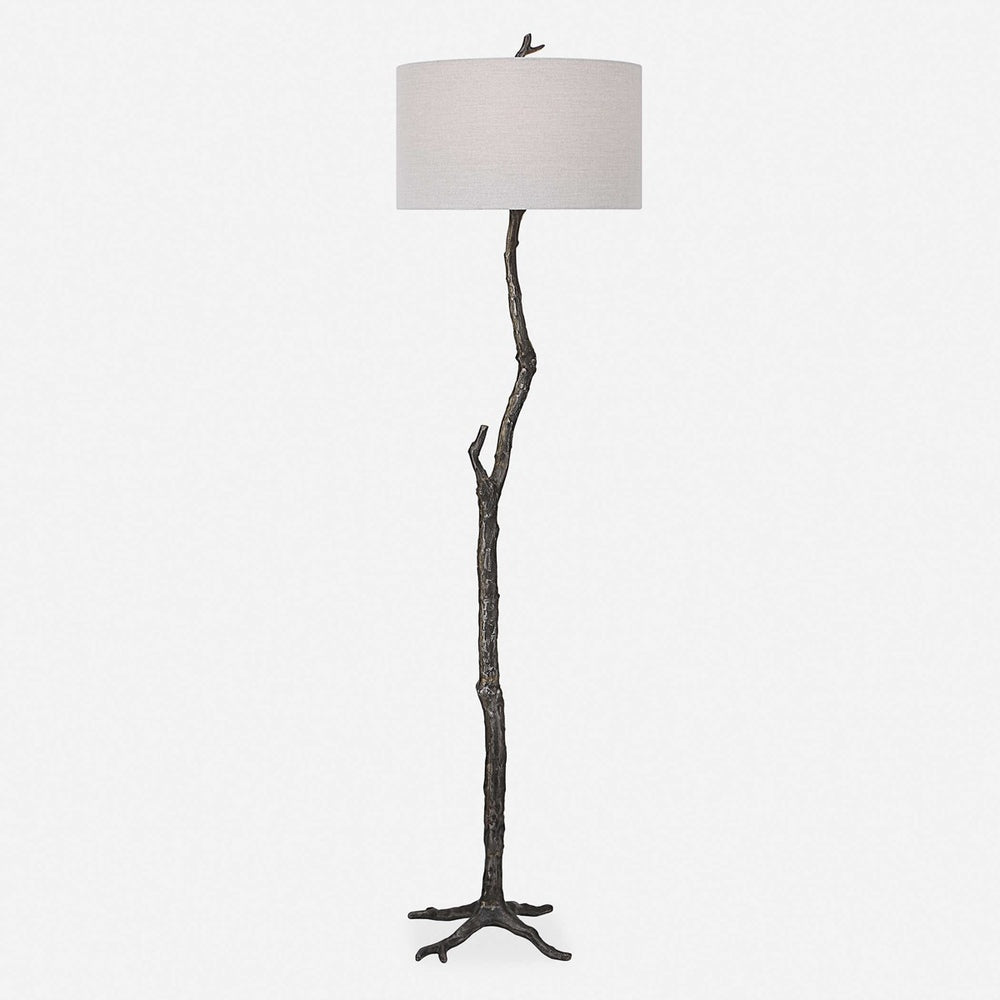 Artistic cast iron floor lamp with a sculptural design resembling natural branches, finished in rustic black with silver undertones.