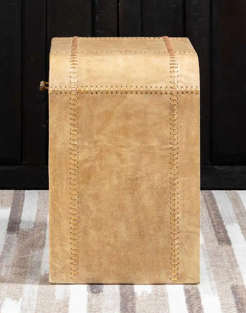 A side profile of the Sahara Sand Leather Nightstand showcasing its curved edges, smooth leather finish, and handwoven leather lacing details.