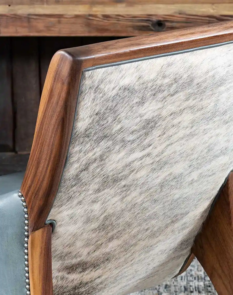 Detailed view of the grey brindle cowhide on the chair’s back, offering a striking contrast with the smooth leather interior.