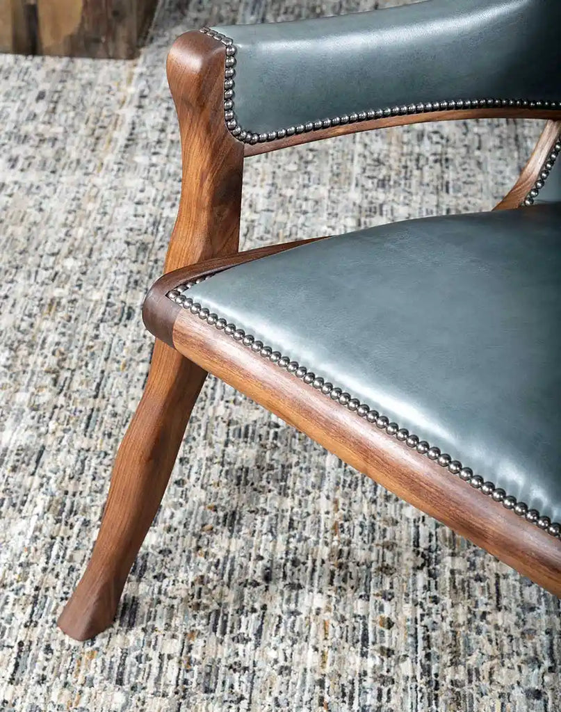 Close-up of finely positioned nickel studs outlining the chair’s curves for a refined, elegant touch.