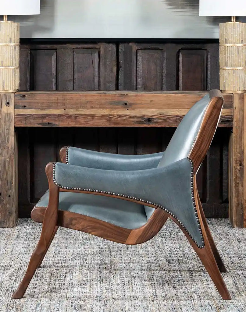 Side view displaying the chair’s sleek contours, nickel stud detailing, and solid black walnut frame.