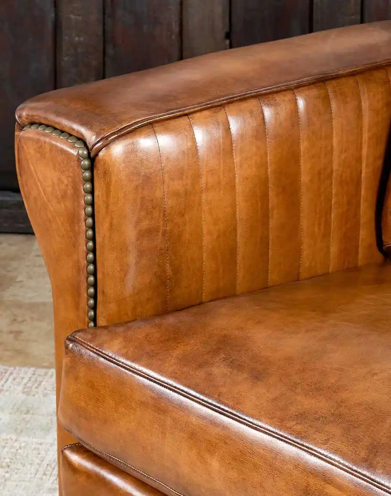 Close-up of the seamless, hand-burnished leather finish on the Herdsman Sofa’s armrest for a sleek and polished look.