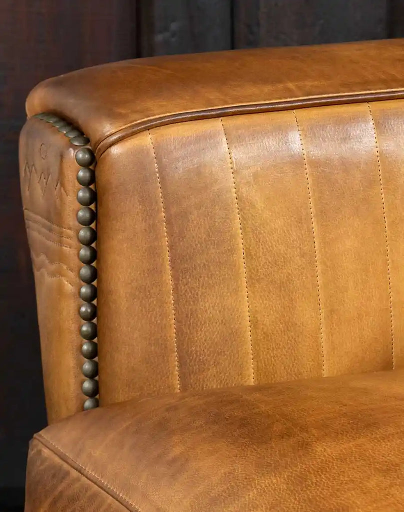 Detailed image focusing on the rich, hand-burnished full-grain leather upholstery, highlighting its warm patina.